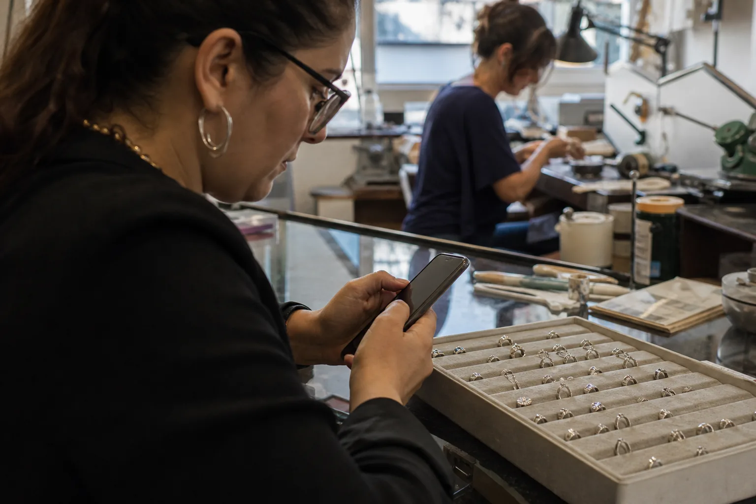 Jeweler preparing a diamond ring and a thank you card for a returning client