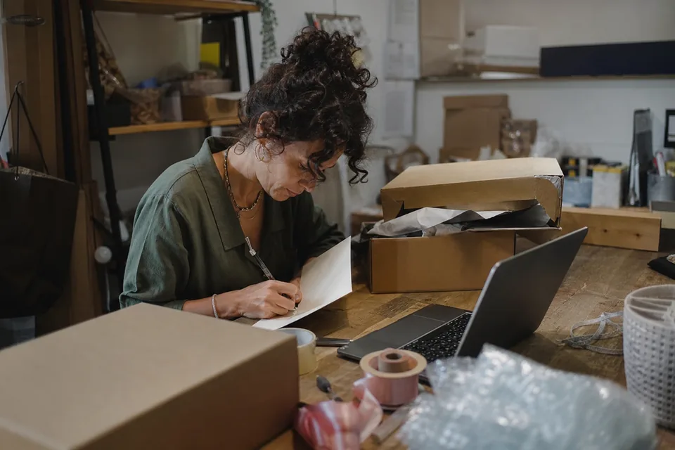 Online store advisor packing a high ticket order with a handwritten note for a returning Shopify customer