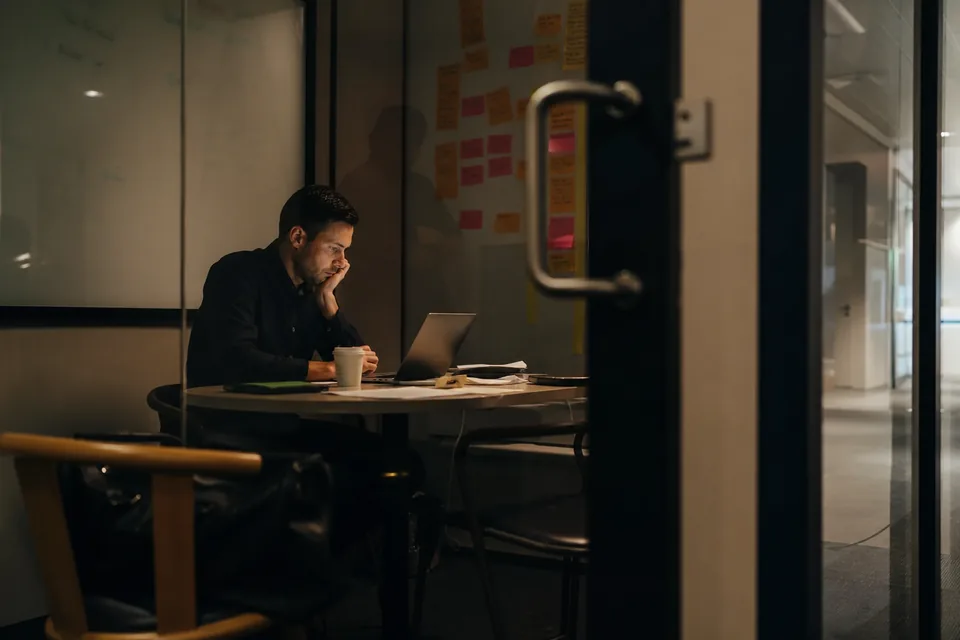 Retail operations manager reviewing client data access and consent records on a laptop in a quiet office